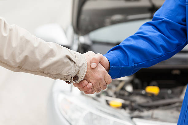 Customer shaking hands with car mechanic.